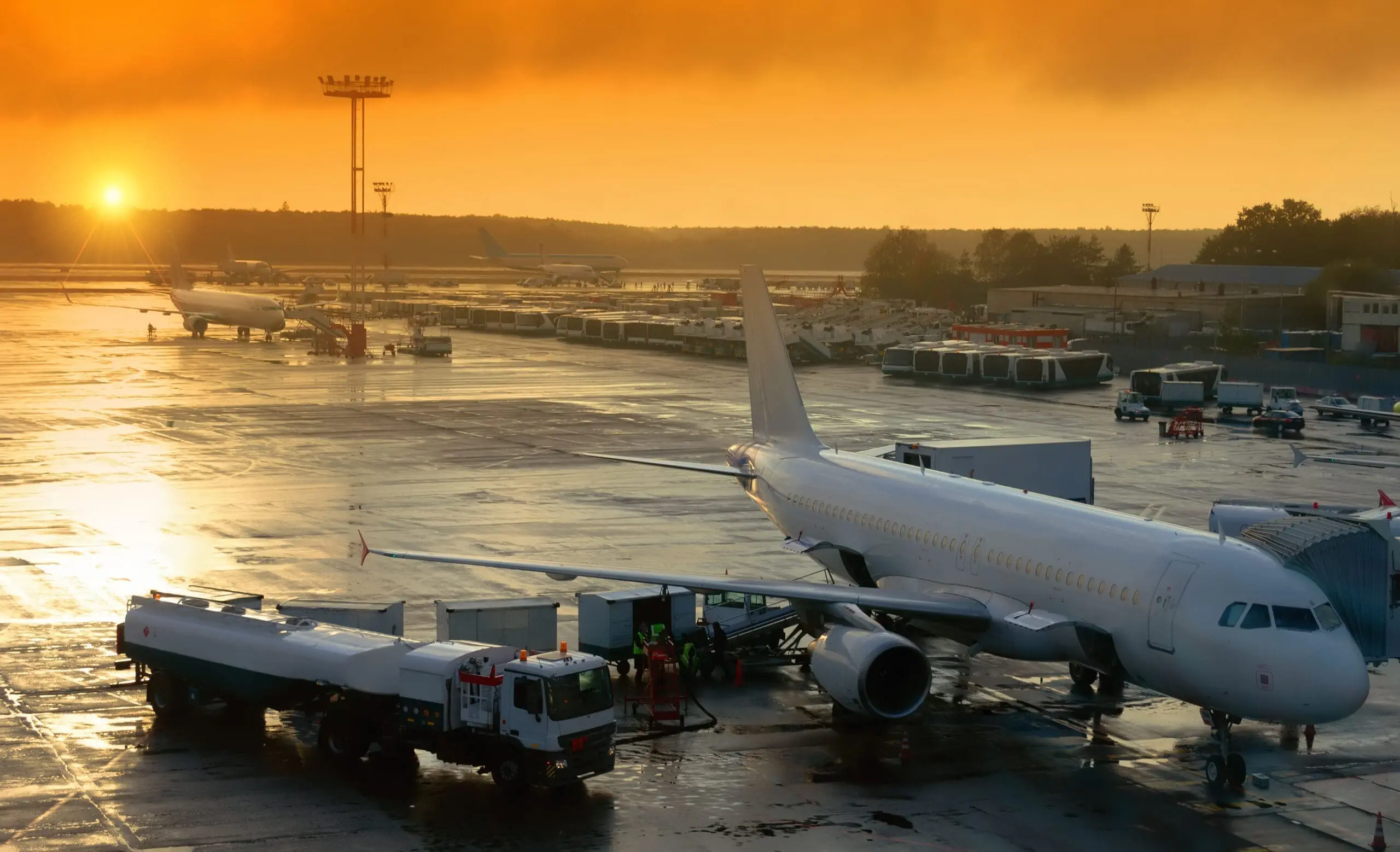 Airplane at airport during sunrise refueling