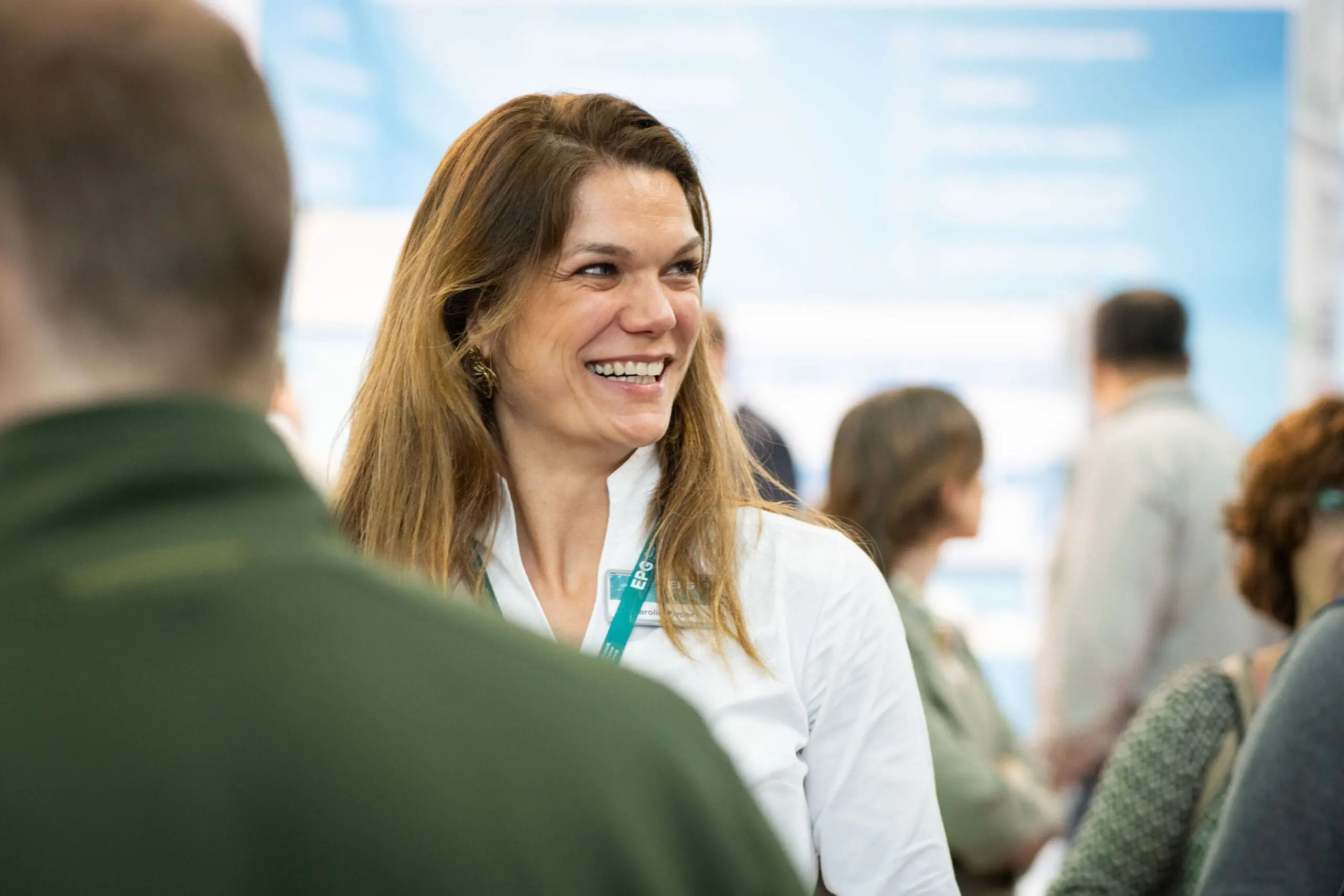 Femme souriante lors d'un événement professionnel.