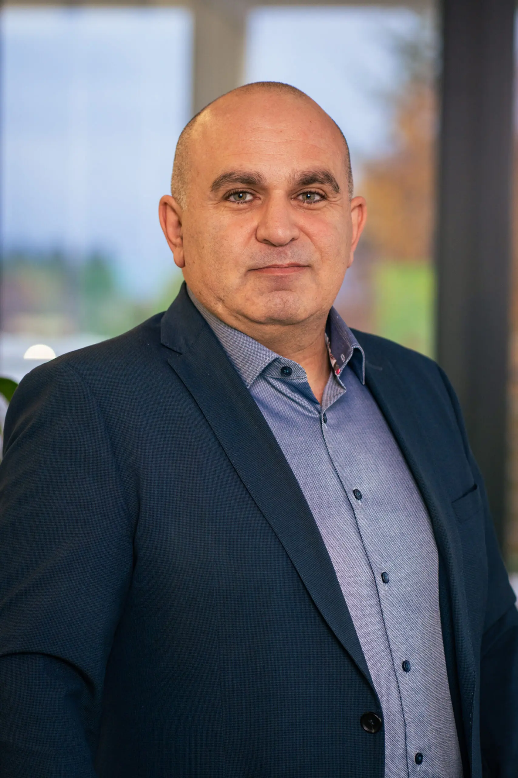Businessman in blue suit, standing confidently.