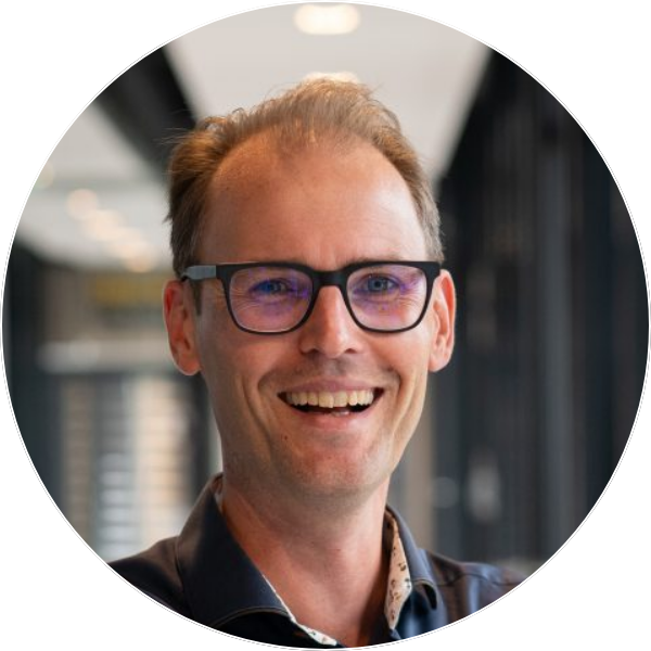 Man smiling in corridor with glasses