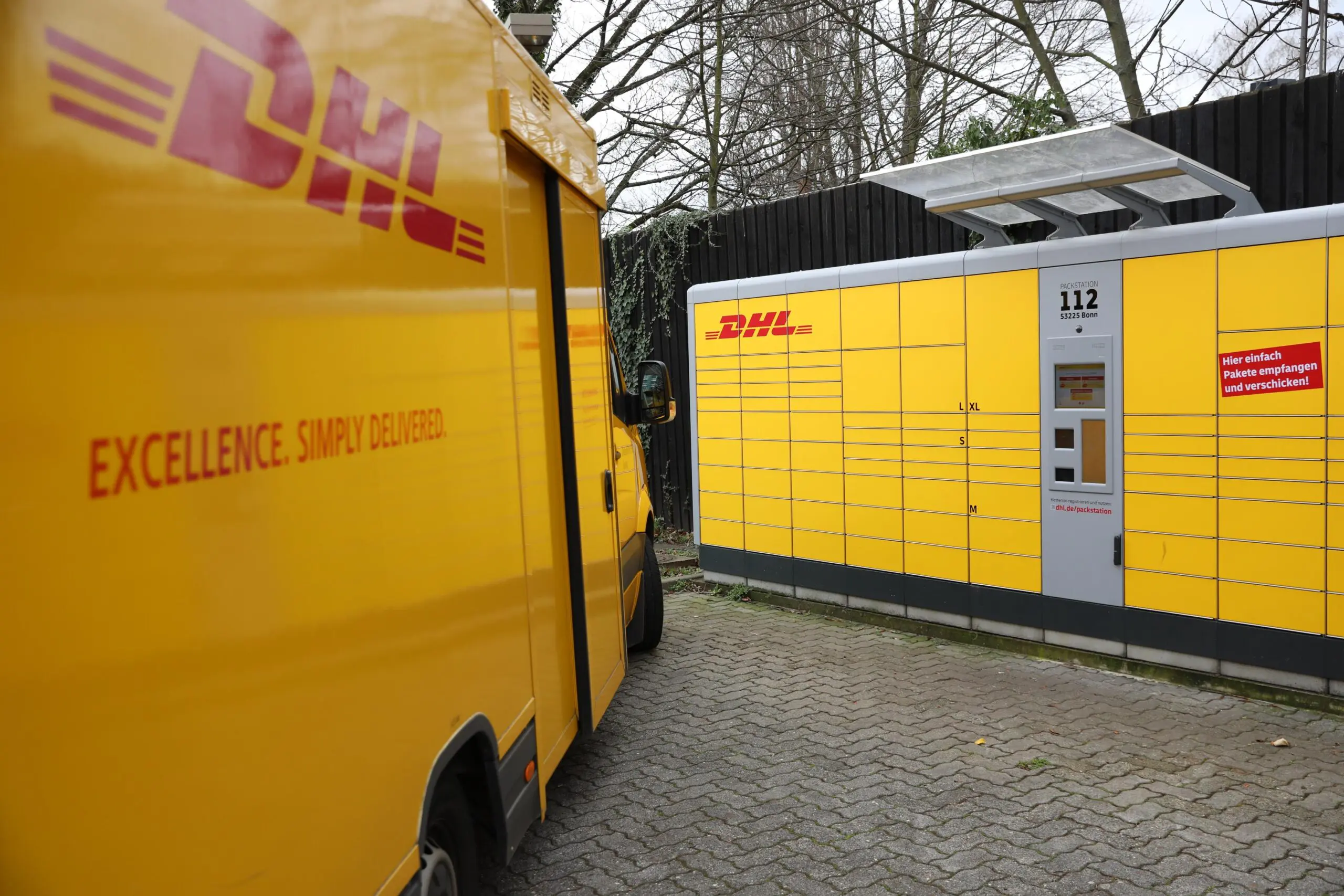 DHL van next to a parcel station.