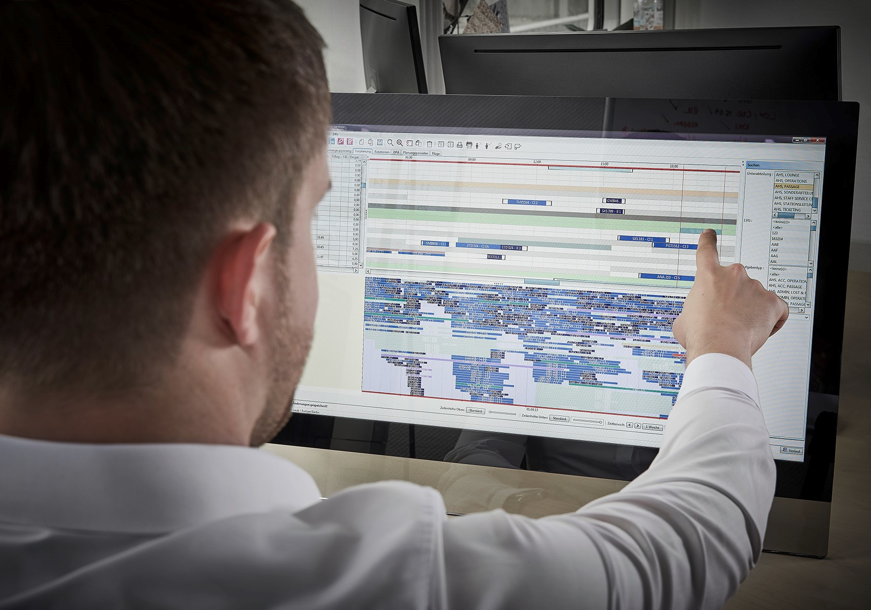 Person pointing at complex data chart on screen