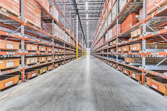 Spacious warehouse aisle with organized shelves.