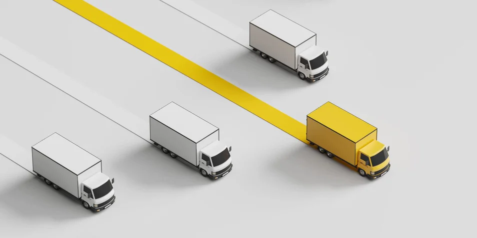 Yellow truck leading white trucks on highway