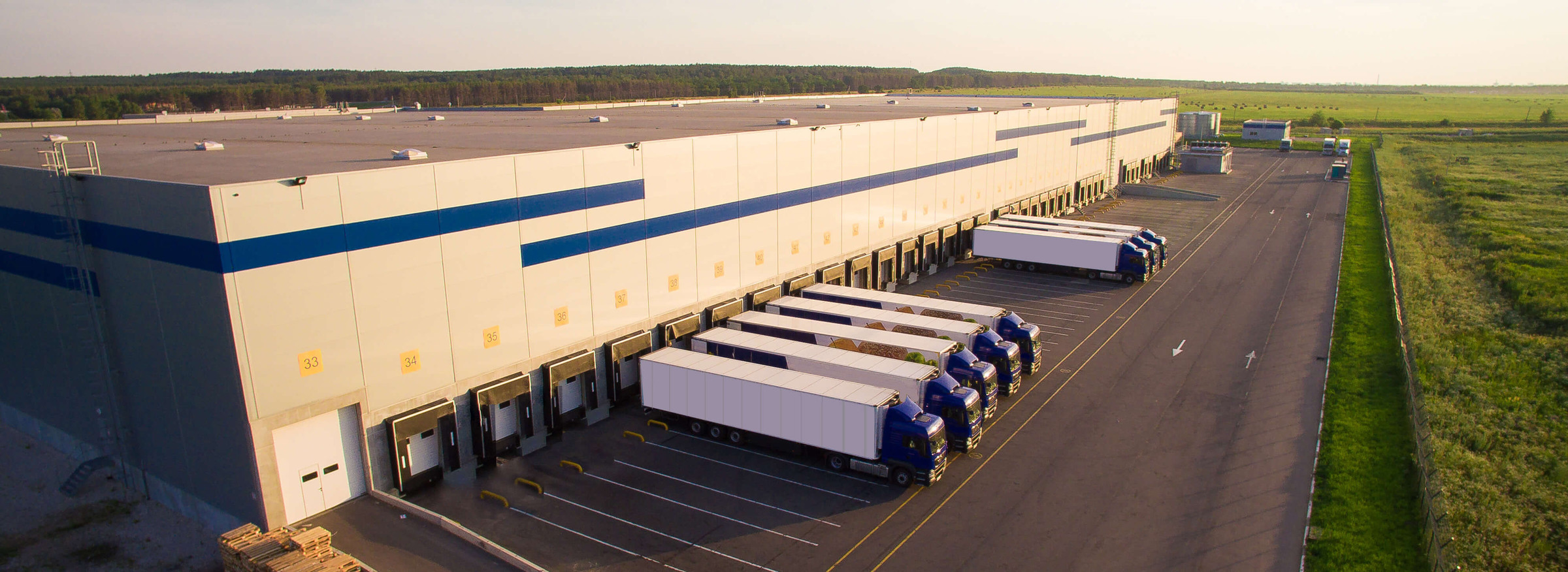 Distribution warehouse with loading trucks and parking.