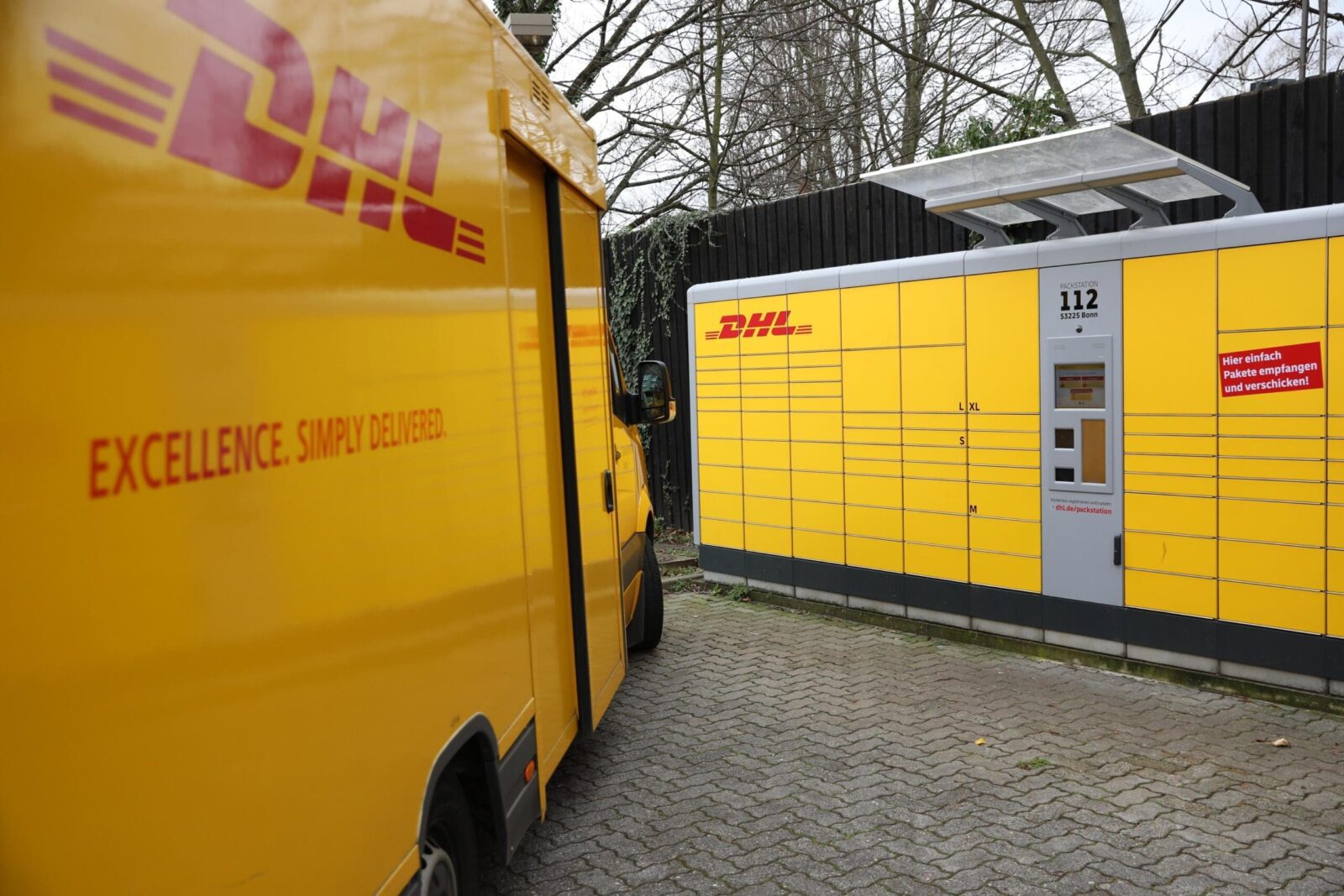 DHL van next to a parcel station.