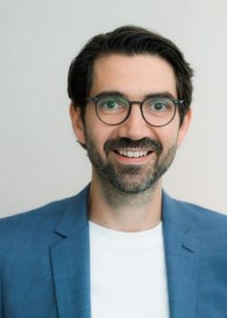 Smiling man in blue suit and glasses