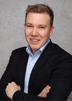 Smiling person in suit with folded arms