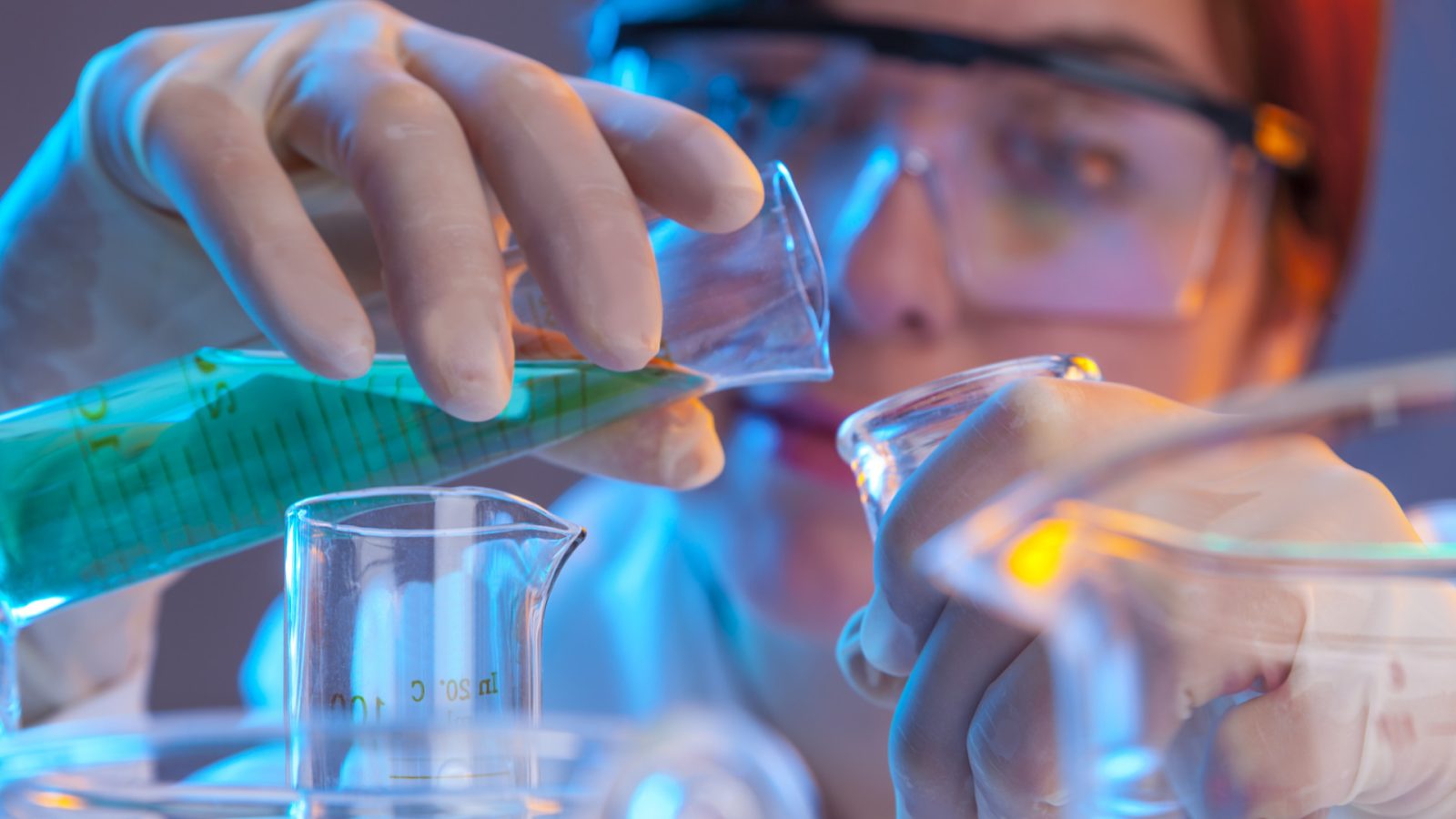 Female scientist looking at a test tube. shallow depth of field.