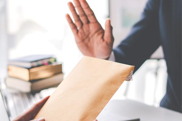 Zwei Personen mit Umschlag und Dokumenten im Büro