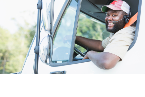 Smiling truck driver wearing headset in vehicle.