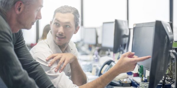 Businessmen reviewing some financial work at the desktop computer.