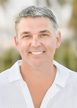 Smiling person in white shirt outdoors