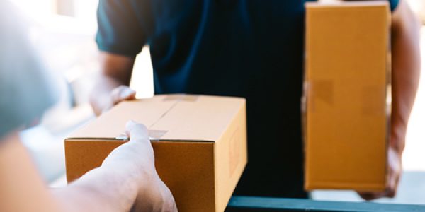 Person delivering cardboard box to customer
