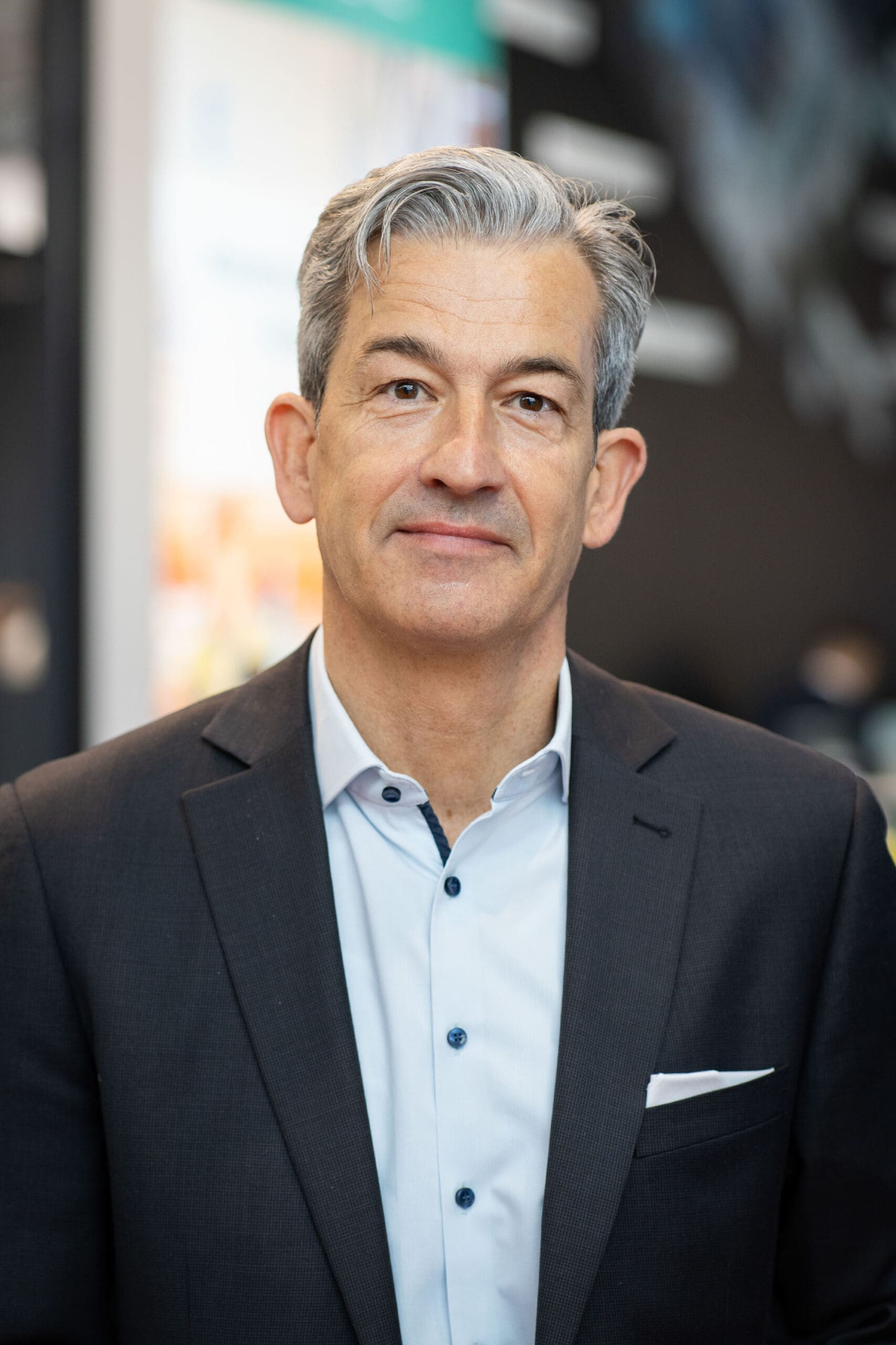 Businessman in suit with neutral expression indoors.