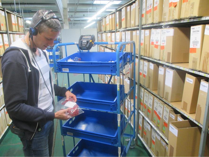 Worker sorting items in warehouse storage.